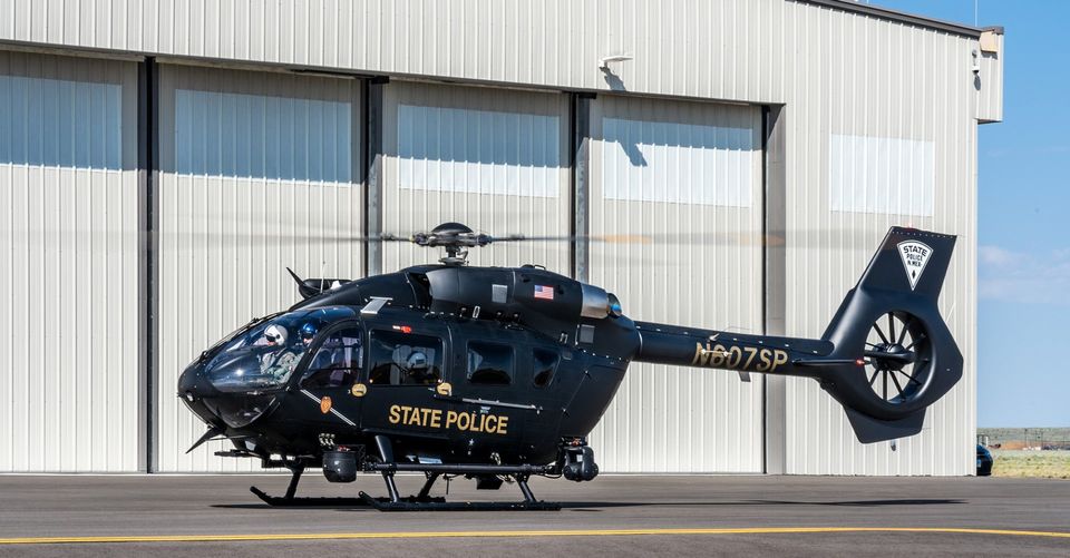 Aircaft Image 1 Black helicopter marked State Police parked outside a large gray hanger